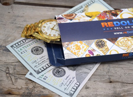 Gold Rolex watch in reDollar envelope with banknotes