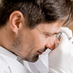 Alan reviewing a green gemstones with jewelers loupe