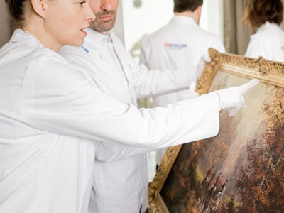 stock image: experts authenticating oil painting for auction