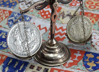 Britannia silver coin and Half crown silver coin on scale for weighing