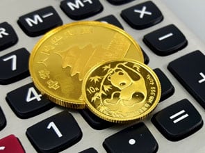 2 China Panda fine gold coins on a calculator