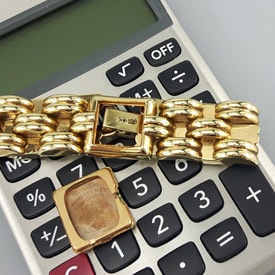 gold watch parts on a calculator