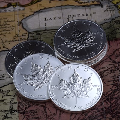 Canadian Maple Leaf silver coins on Canada map