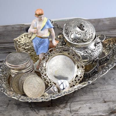 Antique silver and coins mixture with European porcelain figurine on tray