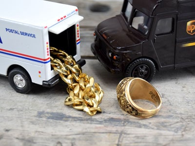 USPS & UPS miniature trucks pick up gold ring and necklace