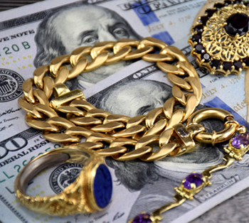 18K gold jewelry on two hundred dollar bank notes