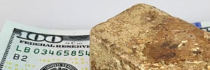 melted gold ingot on 100 dollar bill