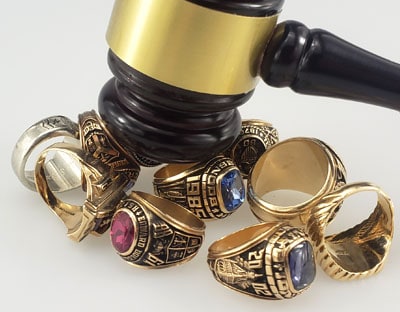 auction hammer hitting gold class rings