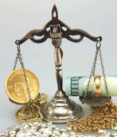 Krugerrand coin on scale with cash and gold ring