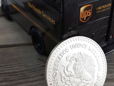 stock image: Pesos silver coin from Mexico and UPS truck