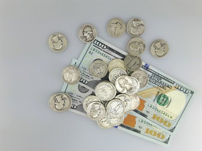 stock image: US silver coins and two 100 hundred dollar bills