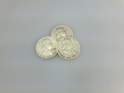 stock image: Franklin silver dollar obverse, 3 half dollar coins