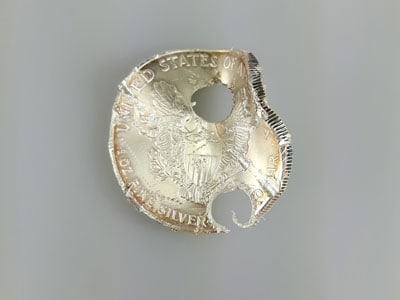 stock image: damaged American Silver Eagle with drill holes