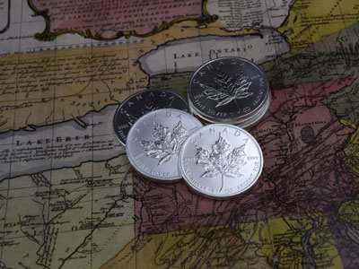 stock image: Canadian Maple Leaf silver coins on Canada map