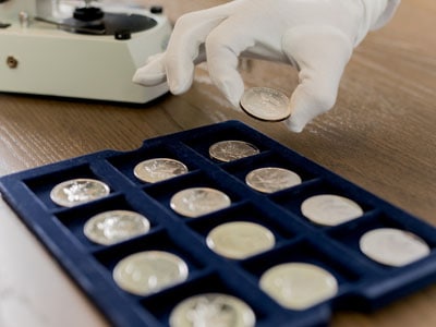 stock image: sorting American silver Eagle coins, cotton glove
