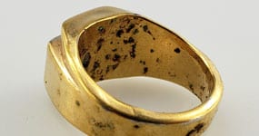 gold colored ring with corrosion showing off copper