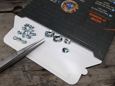 stock image: gem tweezer and loose aquamarine gem collection
