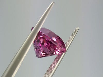 stock image: loose imperial pink topaz gemstone, tweezer