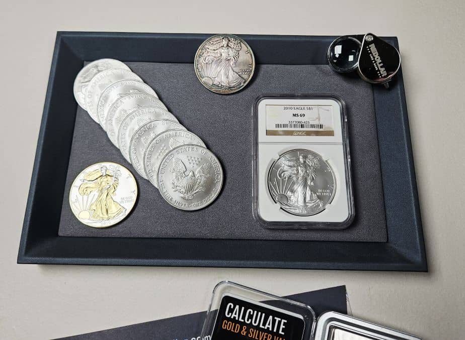 An American Silver Eagle collection on a jewelry tray with a reDollar loupe.