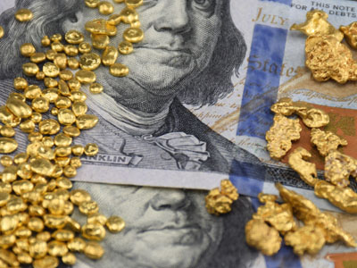 natural gold nuggets and artificial gold granules on 100 dollar bills