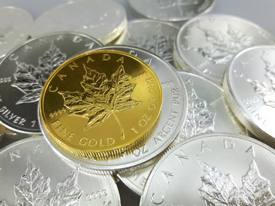 stock image: gold Maple Leaf coin size comparison with silver Maple Leaf coins