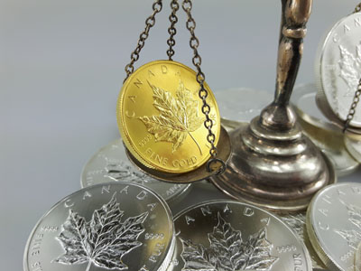 stock image: weighing Maple Leaf gold coin on vintage scale