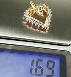 jewelry scale displaying 1.69 grams for gold pendant