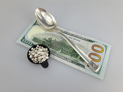 stock image: 100 dollar bill, silver spoon and silver nuggets