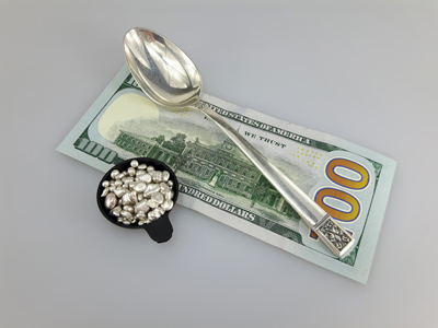 stock image: 100 dollar bill, silver spoon and silver nuggets