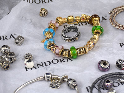 stock image: Pandora silver charms, gold and leather bracelet