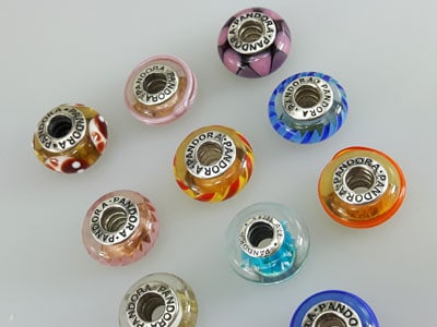 stock image of Pandora Murano charms in blue, orange, pink, red and green