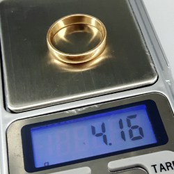 weighing gold wedding ring on scale