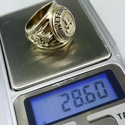 weighing Texas Tech University gold ring with scale