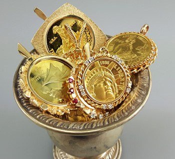 scrap gold coin pendants in a sterling silver cup