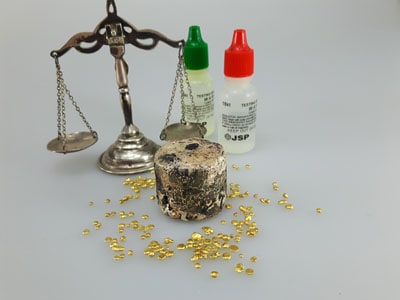 stock image: scrap gold, gold acid for testing and vintage scale