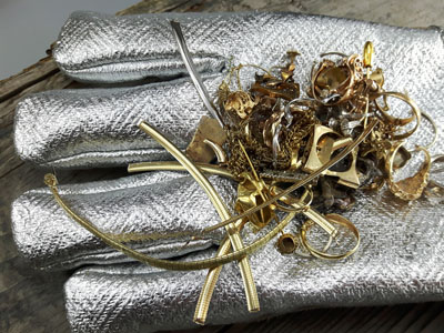 stock image: scrap gold carried with heat-resistant melting glove