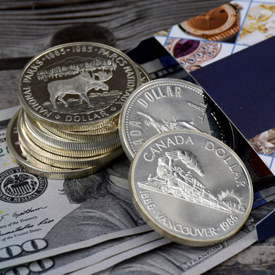 Canada Dollar silver coins on US dollars and envelope