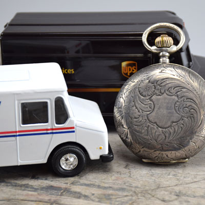 UPS and USPS Truck with silver pocket watch for shipping