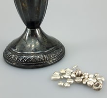 silver granules displayed next to weighted silver candle holder