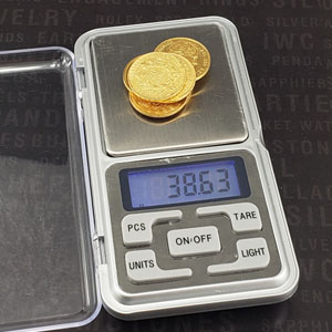 gold coins placed on digital scale for weighing purpose