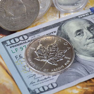 Canadian silver coins in 100 dollar bill