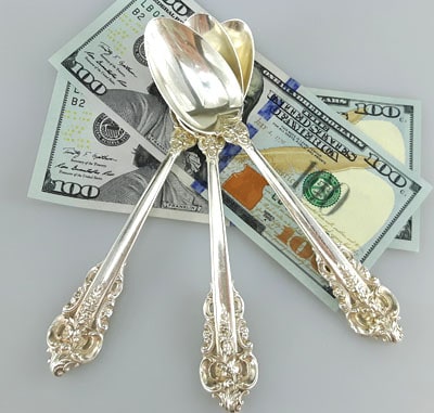 Wallace silver spoons on 100 dollar bills