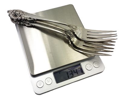 Weighing sterling silver forks on a scale
